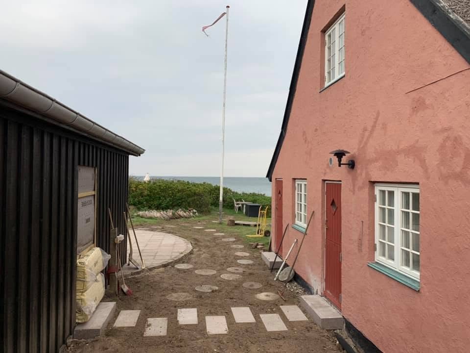 Sommerhuset med færdig trædestensti og rund plads ned mod vandet