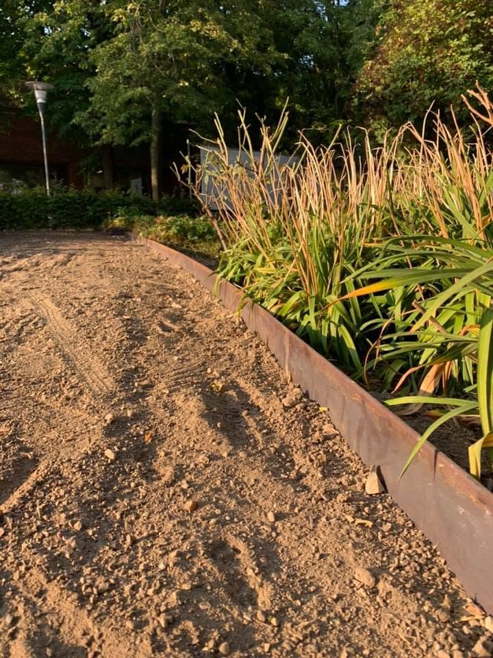 Corten-stålkant mod bed med prydgræsser