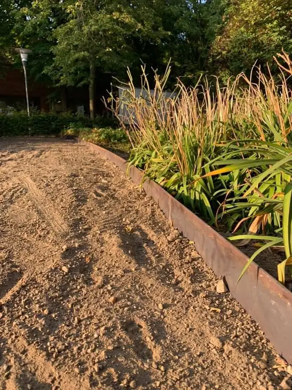 Corten-stålkant mod bed med prydgræsser