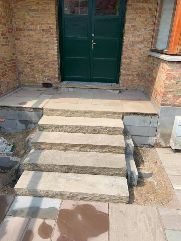 Trappe i massive sandstensblokke med kløvet forkant op til hoveddøren